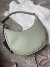 Load image into Gallery viewer, Crescent shaped, sage green purse with caribou hair tufting on moose hide.
